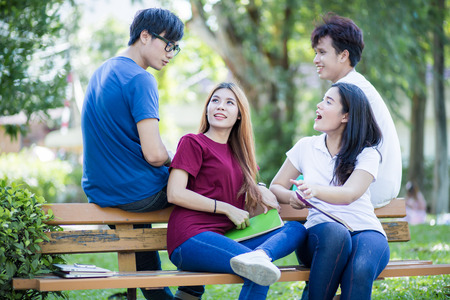 Group of students sharing with the ideas on the campus lawnの写真素材