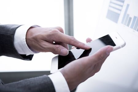 Young businessman working with modern devices, digital tablet computer and mobile phone.の写真素材
