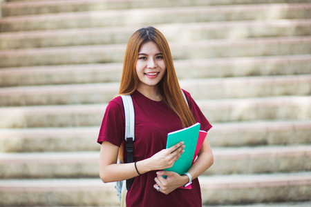 Smiling college student sitting on staircaseの写真素材