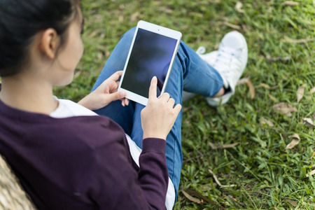 Young woman using tablet in park