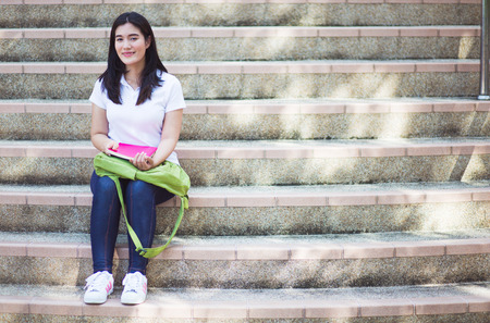Smiling college student sitting on staircaseの写真素材
