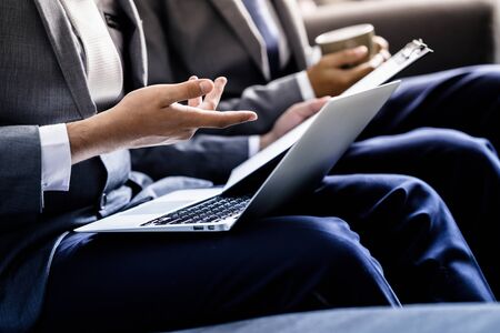 Image of two young businessmen discussing project at meetingの写真素材