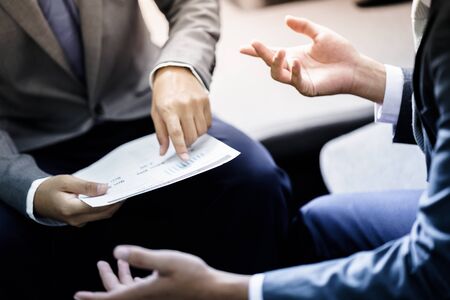 Image of male hand pointing at business document during discussion at meetingの写真素材