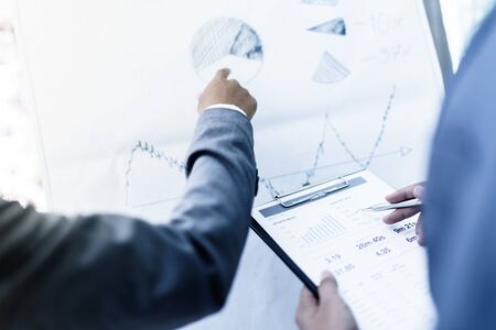 Image of two young businessmen discussing project at meeting