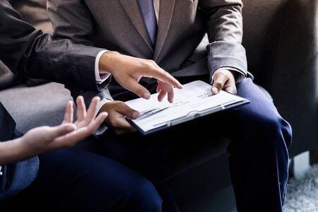 Image of two young businessmen discussing project at meetingの写真素材