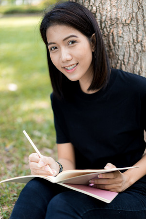 Girl reading a book in parkの写真素材
