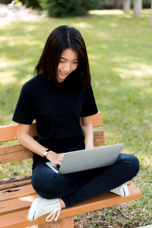 Beautiful young woman using laptop at outdoorの写真素材