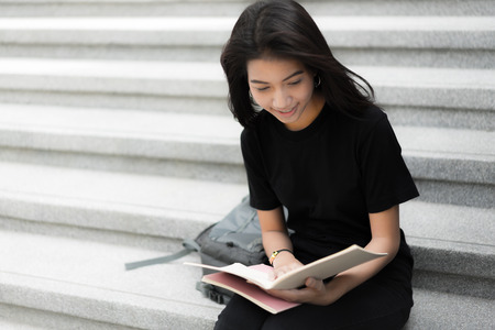 Smiling college student sitting on staircaseの写真素材