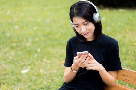 pretty women in the park listening musicの写真素材