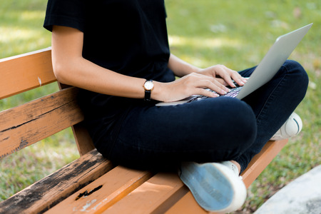 Beautiful young woman using laptop at outdoorの写真素材