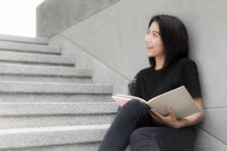 Smiling college student sitting on staircaseの写真素材