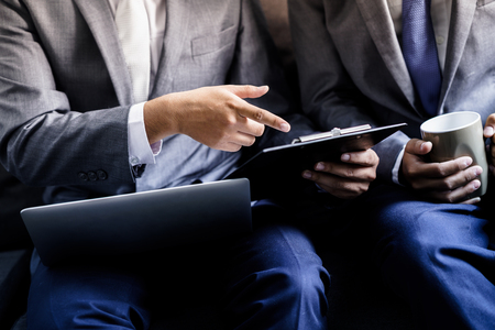 Image of two young businessmen discussing project at meetingの写真素材