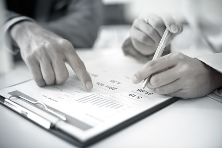 Business people discussing the charts and graphs showing the results of their successful teamworkの写真素材