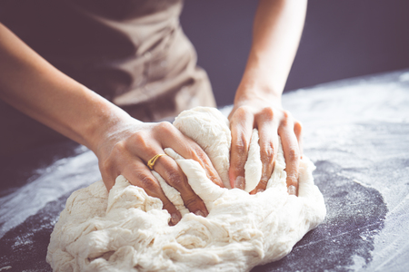 Making dough by female hands at bakeryの写真素材