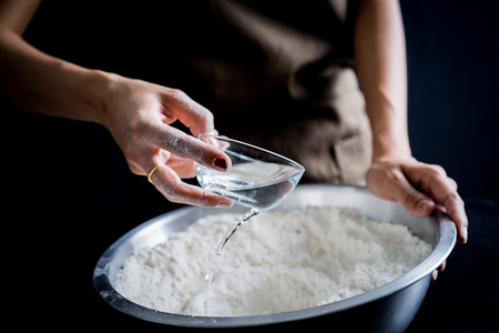 Making dough by female hands at bakeryの写真素材