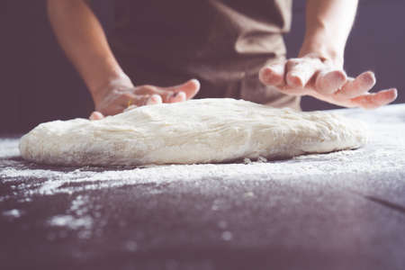 Making dough by female hands at bakeryの写真素材