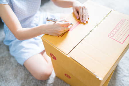 Woman signs papers among parcels. Delivery conceptの写真素材
