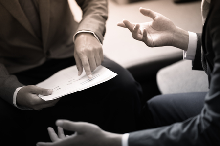 Image of male hand pointing at business document during discussion at meetingの写真素材