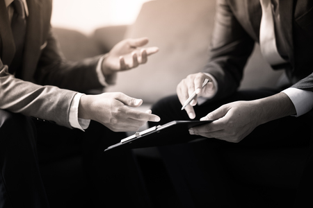 Image of two young businessmen discussing project at meetingの写真素材