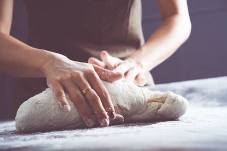 Making dough by female hands at bakeryの写真素材
