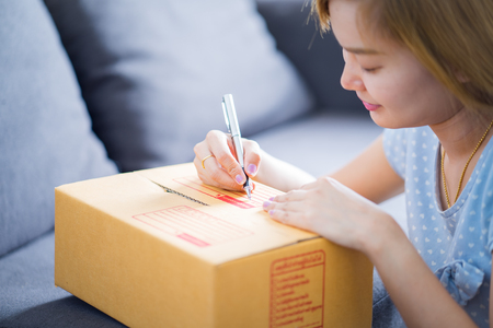 Woman signs papers among parcels. Delivery conceptの写真素材