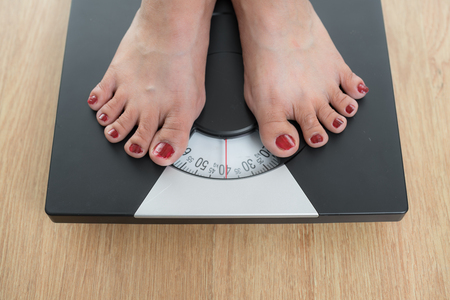 Slim woman on weighting scalesの写真素材