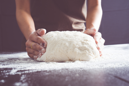 Making dough by female hands at bakeryの写真素材