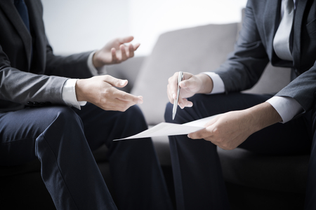 Image of two young businessmen discussing project at meetingの写真素材