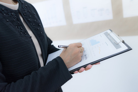 Businesswoman analyzing her project on boardの写真素材