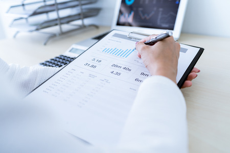 Business women reviewing data in financial charts and graphs