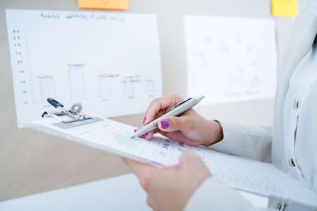 Asian businesswoman analyzing her project on boardの写真素材