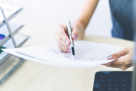 Business women reviewing data in financial charts and graphs in the officeの写真素材
