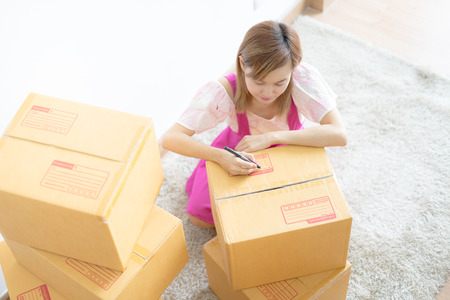 Young Asian woman working online shopping at home office, Packaging and delivery sceneの写真素材