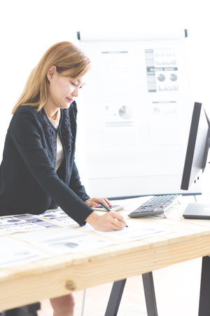 Business women reviewing data in financial charts and graphs. Accountingの写真素材