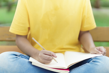 Student reading a book in parkの写真素材