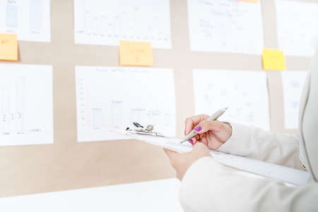 Asian businesswoman analyzing her project on boardの写真素材