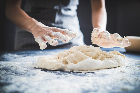 Making dough by female hands at bakeryの写真素材