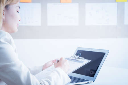 Asian business women reviewing data in financial charts and graphs