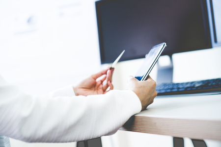 Woman Hands holding credit card and using mobile. Online shoppingの写真素材