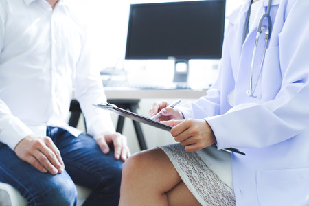 Doctor and patient discussing something while sitting. Medicine and health care concept