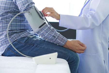 Close-up of patient arm during blood pressure measuring at medical consultation