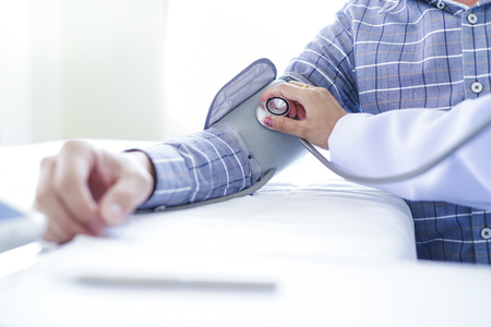 Close-up of patient arm during blood pressure measuring at medical consultationの写真素材