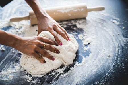 Making dough by female hands at bakeryの写真素材