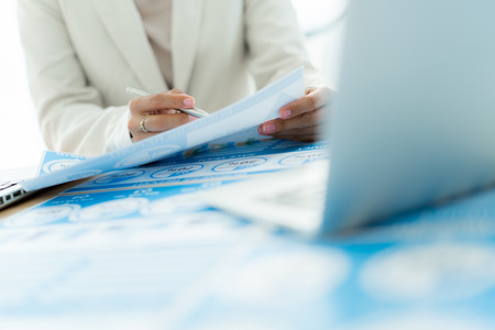 Business women reviewing data in financial charts and graphs. Accountingの写真素材