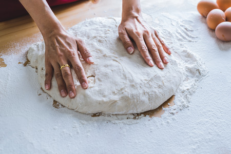 Making dough by female hands at bakery