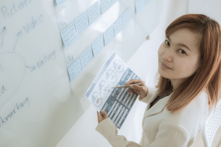 Asian business woman reviewing data in financial charts and graphs. Accountingの写真素材
