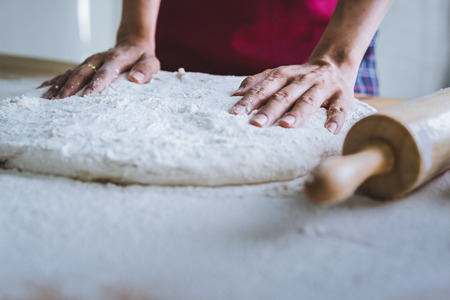 Making dough by female hands at bakeryの写真素材
