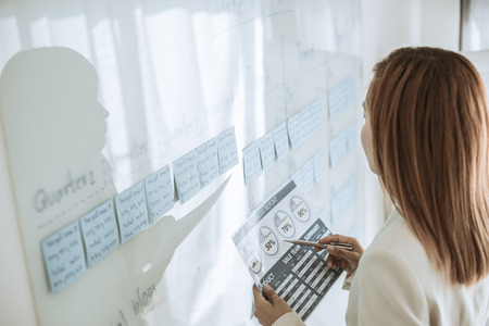Asian business woman reviewing data in financial charts and graphs. Accounting