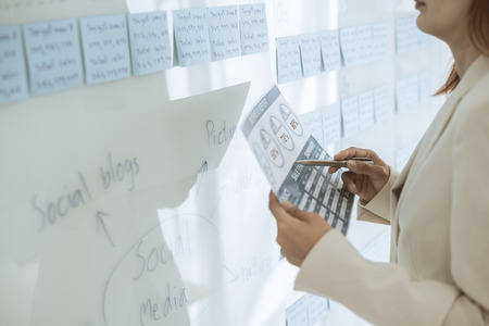 Asian business woman reviewing data in financial charts and graphs. Accounting