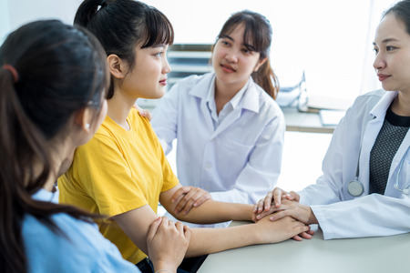 Hand of doctor reassuring her female patientの写真素材